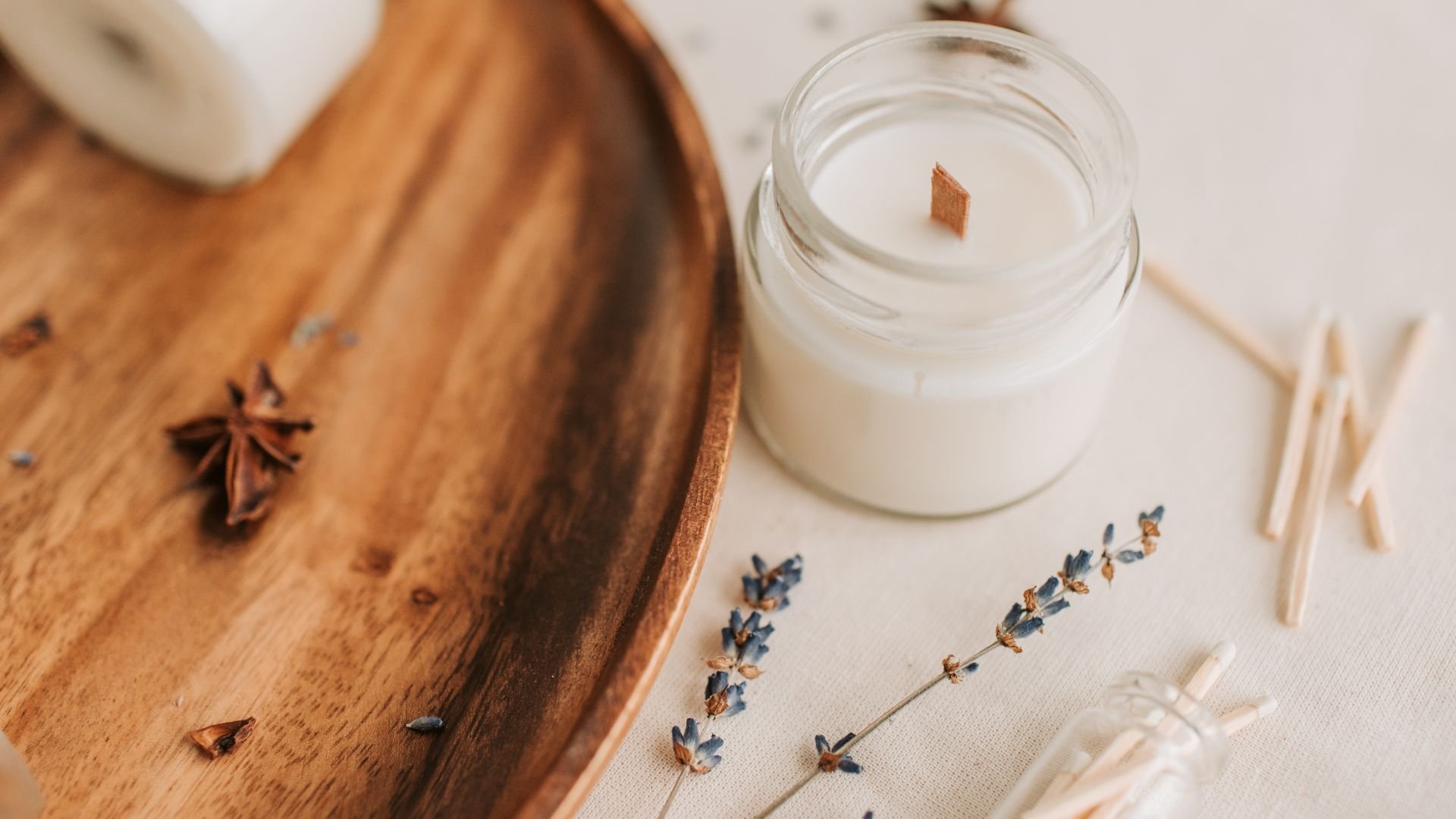 Scented candle with lavender, star anise, and wooden background