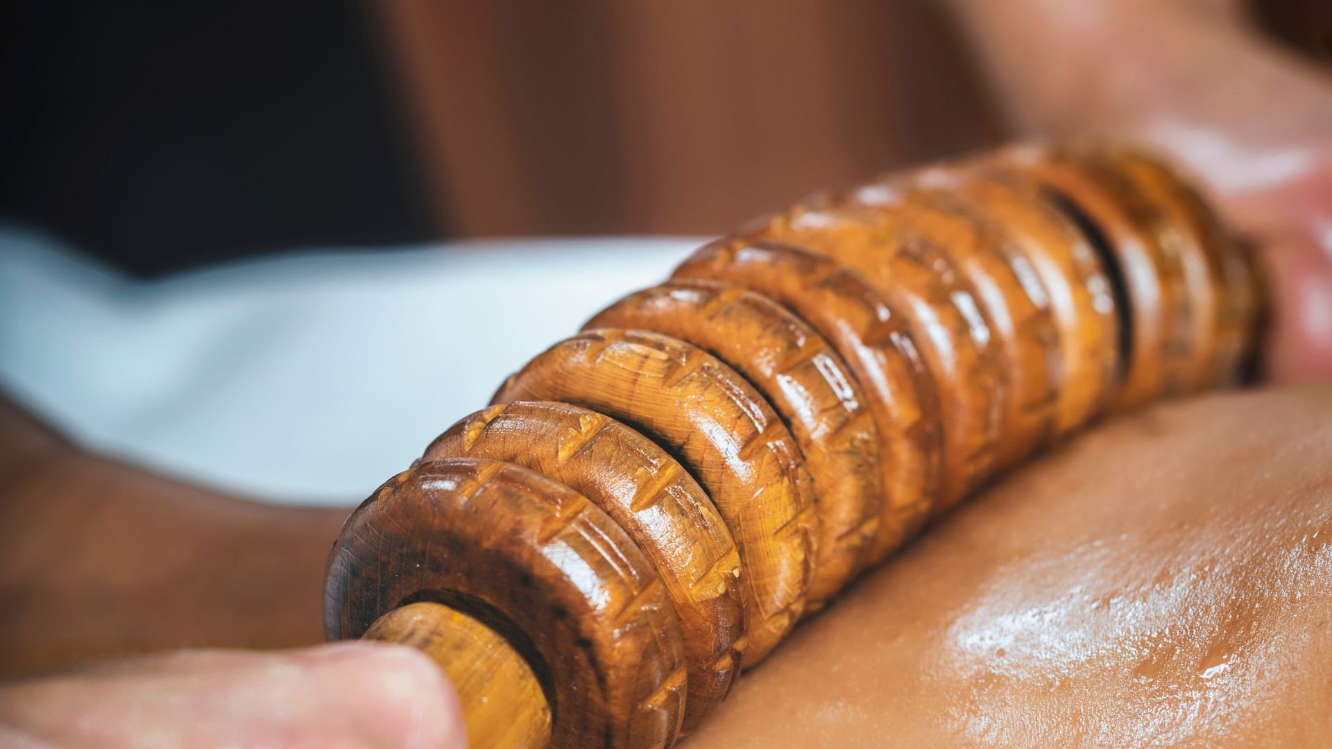 Wooden textured rolling pin with carved patterns on kitchen surface