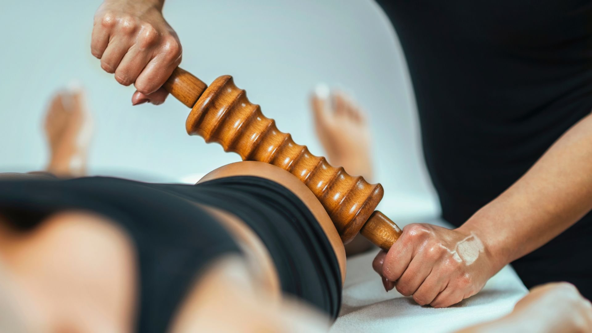 Wooden massage roller used for deep tissue muscle therapy on back